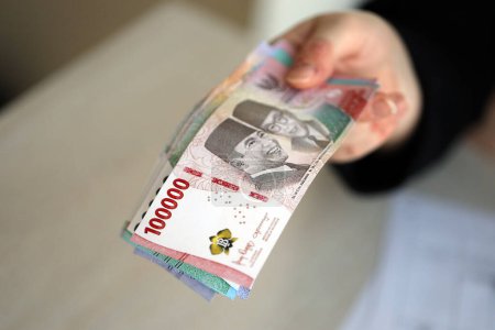 Femme comptable main donner bouquet de nombreux indonésien roupie billets d'argent de la nouvelle série close up