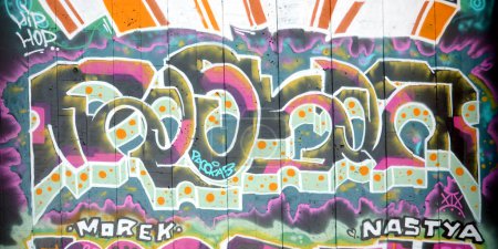 Photo for The old wall decorated with paint stains in the style of street art culture. Colorful background of full graffiti painting artwork with bright aerosol outlines on wall. Colored background texture - Royalty Free Image