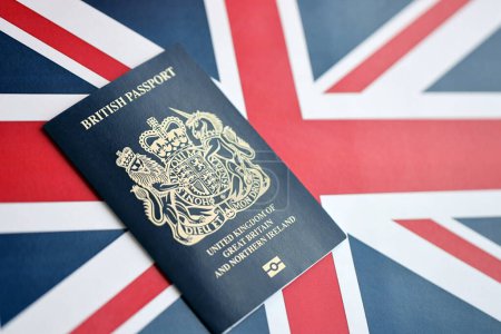 Blauer britischer Pass vor Hintergrund der Nationalflagge. Tourismus- und Bürgerschaftskonzept