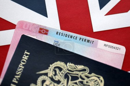 Residence Permit BRP card and British Passport of United Kingdom on Union Jack flag close up