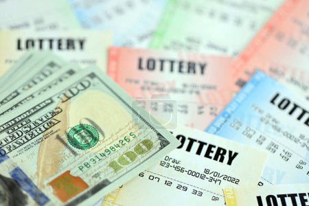 Téléchargez les photos : De nombreux billets de loterie et billets en dollars sur les billets en blanc avec des numéros pour jouer à la loterie fermer - en image libre de droit