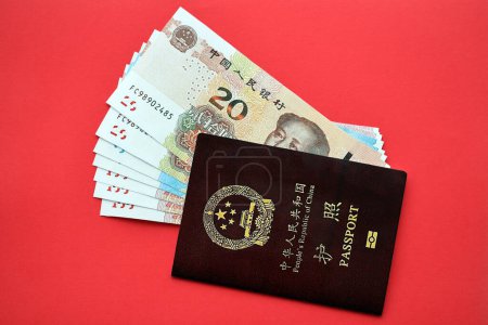 Pasaporte rojo de la República Popular China y billetes de yuan chino. pasaporte chino de la República Popular China sobre fondo brillante de cerca