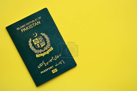 Grüner Pass der Islamischen Republik Pakistan auf gelbem Hintergrund in Großaufnahme. Tourismus- und Bürgerschaftskonzept