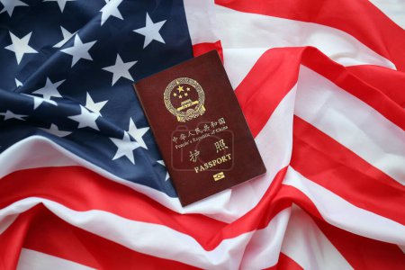 Roter Pass der Volksrepublik China auf der Flagge der Vereinigten Staaten. Chinesischer Pass der Volksrepublik China auf hellem Hintergrund in Nahaufnahme