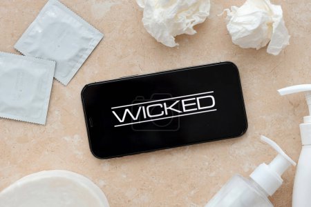 Photo for KYIV, UKRAINE - JANUARY 23, 2024 Wicked adult content website logo on display of iPhone 12 Pro smartphone - Royalty Free Image
