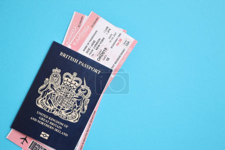 Blauer britischer Pass mit Flugtickets auf blauem Hintergrund in Großaufnahme. Tourismus- und Reisekonzept