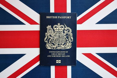 Blauer britischer Pass vor Hintergrund der Nationalflagge. Tourismus- und Bürgerschaftskonzept
