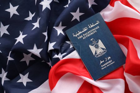 Blue Palestinian Authority passport on United States national flag background close up. Tourism and diplomacy concept