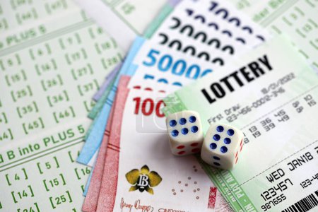 Billetes de lotería verde y billetes de dinero indonesio en blanco con números para jugar a la lotería de cerca