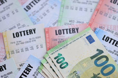 Viele Lotterielose und Euro-Scheine auf Blankoscheinen mit Zahlen zum Lotteriespiel aus nächster Nähe