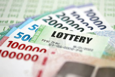 Grüne Lotterielose und indonesische Geldscheine auf Blanko mit Zahlen zum Lotteriespiel aus nächster Nähe