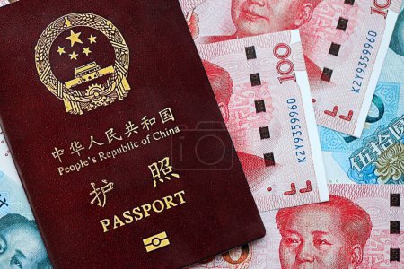 Red passport of People Republic of China and chinese yuan money bills. PRC chinese passport on bright background close up