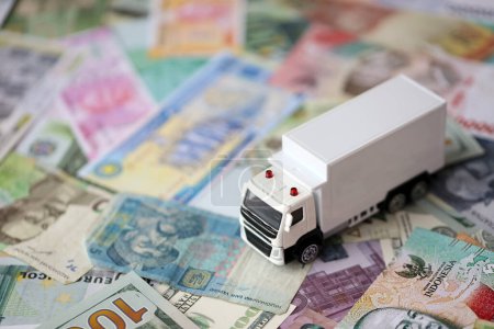 Lieferwagen auf vielen Banknoten verschiedener Währung. Hintergrund des Truck- oder Umzugskonzepts hautnah