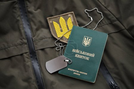 Boleto de identificación militar o militar se encuentra en uniforme militar ucraniano verde en el interior de cerca