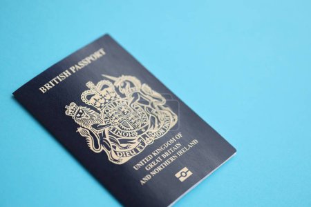 Blue British passport on blue background close up. Tourism and citizenship concept