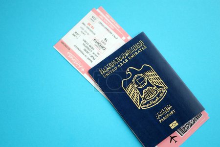 Reisepass der Vereinigten Arabischen Emirate mit Flugtickets auf blauem Hintergrund in Großaufnahme. Tourismus- und Reisekonzept