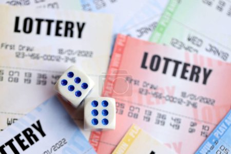 Muchos billetes de lotería y dados en billetes en blanco con números para jugar a la lotería de cerca