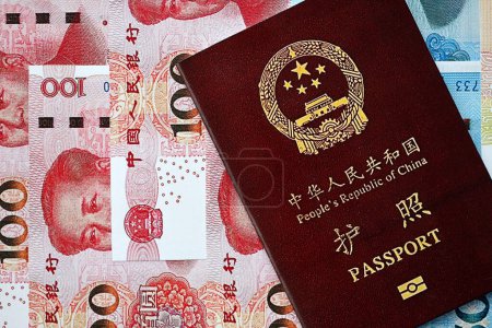 Passeport rouge de la République populaire de Chine et billets chinois en yuan. Chine passeport chinois sur fond lumineux fermer