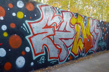 La antigua pared decorada con manchas de pintura en el estilo de la cultura del arte callejero. Fondo colorido de la pintura de graffiti completa con contornos brillantes en aerosol en la pared. Textura de fondo coloreado