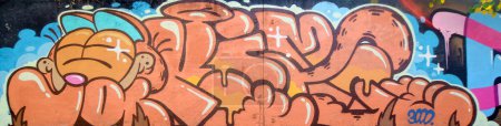 Foto de La antigua pared decorada con manchas de pintura en el estilo de la cultura del arte callejero. Fondo colorido de la pintura de graffiti completa con contornos brillantes en aerosol en la pared. Textura de fondo coloreado - Imagen libre de derechos