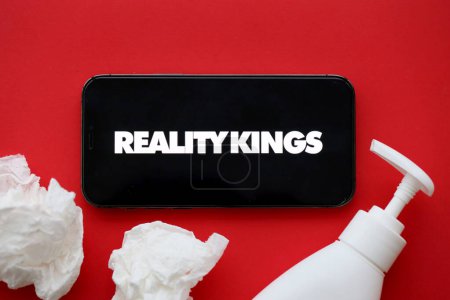 Foto de KYIV, UCRANIA - 23 de enero de 2024 RealityKings logotipo del sitio web de contenido para adultos en la pantalla del teléfono inteligente iPhone 12 Pro - Imagen libre de derechos