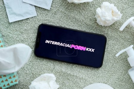Photo for KYIV, UKRAINE - JANUARY 23, 2024 InterracialPorn adult content website logo on display of iPhone 12 Pro smartphone - Royalty Free Image