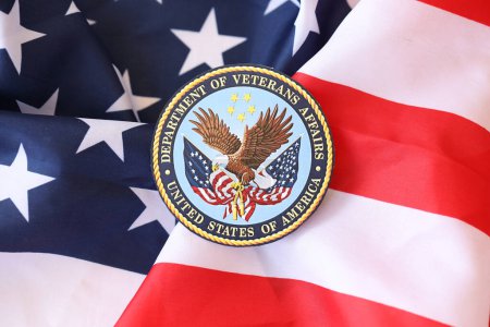 Photo for KYIV, UKRAINE - MARCH 9, 2024 US Department of Veteran Affairs seal on United States of America flag close up - Royalty Free Image