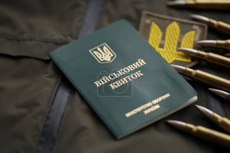 Militärmarke oder Armeeausweis liegt auf grüner ukrainischer Militäruniform drinnen in Großaufnahme