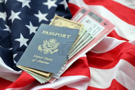 Passeport bleu des États-Unis d'Amérique avec de l'argent et des billets d'avion sur fond de drapeau américain fermer. Tourisme et concept de voyage