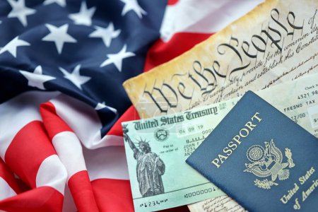 Präambel zur Verfassung der Vereinigten Staaten, US-Pass und Rückerstattungsprüfung auf amerikanischer Flagge. Altes gelbes Papier mit Wir-das-Volk-Text