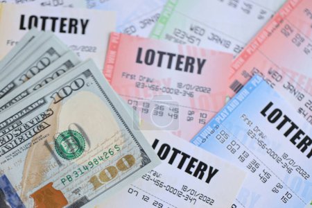 Muchos billetes de lotería y billetes de dólar en billetes en blanco con números para jugar a la lotería de cerca