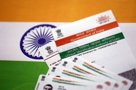 Téléchargez les photos : Carte indienne Aadhaar de l'autorité d'identification unique de l'Inde sur drapeau indien gros plan - en image libre de droit