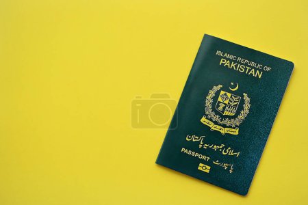Pasaporte de la República Islámica Verde de Pakistán sobre fondo amarillo de cerca. Concepto de turismo y ciudadanía
