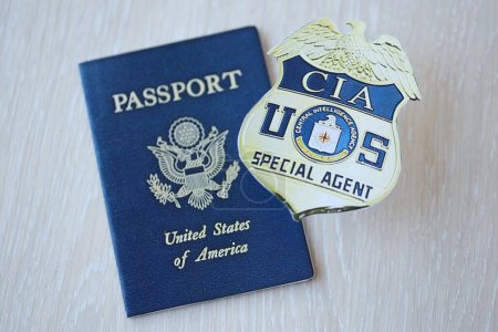 Foto de KYIV, UCRANIA - 9 de marzo de 2024 US CIA Central Intelligence Agency badge and United States passport on wooden table close up - Imagen libre de derechos