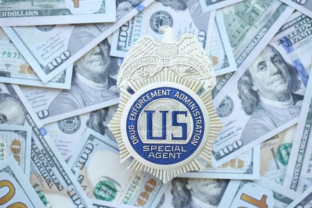 Téléchargez les photos : KYIV, UKRAINE - 9 MARS 2024 US DEA Insigne d'agent spécial sur plusieurs billets de cent dollars américains fermer - en image libre de droit