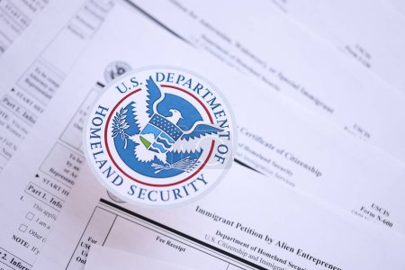 Foto de KYIV, UCRANIA - 9 de marzo de 2024 Departamento de Seguridad Nacional de EE.UU. sellan en muchos formularios de inmigración USCIS de cerca - Imagen libre de derechos