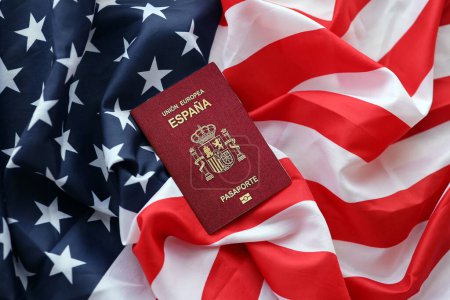 Roter spanischer Pass der Europäischen Union auf dem Hintergrund der Nationalflagge der Vereinigten Staaten in Großaufnahme. Tourismus- und Diplomatie-Konzept