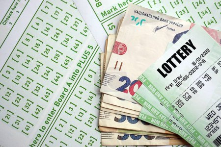 Téléchargez les photos : Billets de loterie verte et des billets de monnaie ukrainiens à blanc avec des numéros pour jouer à la loterie fermer - en image libre de droit
