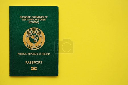 Pasaporte verde nigeriano sobre fondo amarillo de cerca. Concepto de turismo y ciudadanía
