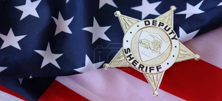 Foto de KYIV, UCRANIA - 9 de marzo de 2024 Insignia del Sheriff Adjunto de los Estados Unidos en la bandera de los Estados Unidos de América de cerca - Imagen libre de derechos