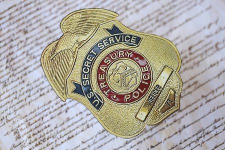 Foto de KYIV, UCRANIA - 9 de marzo de 2024 US Treasury Police Secret Service Officer badge on United States Constitution close up - Imagen libre de derechos