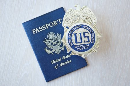 Téléchargez les photos : KYIV, UKRAINE - 9 MARS 2024 US DEA Insigne d'agent spécial et passeport américain sur table en bois close up - en image libre de droit