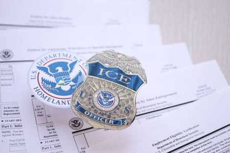 Foto de KYIV, UCRANIA - 9 de marzo de 2024 EE.UU. placa oficial de ICE y sello del Departamento de Seguridad Nacional en USCIS formularios de inmigración de cerca - Imagen libre de derechos
