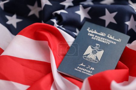 Blue Palestinian Authority passport on United States national flag background close up. Tourism and diplomacy concept