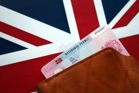 Residence Permit BRP card in purse on Union Jack flag close up