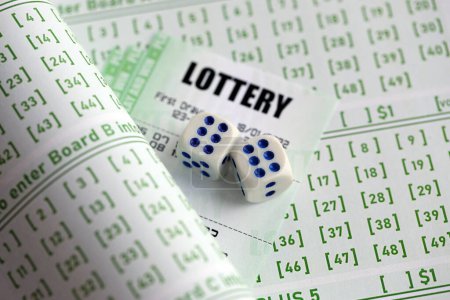 Photo for Lottery tickets and dice on blank bills with numbers for playing lottery close up - Royalty Free Image