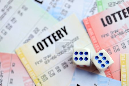 Viele Lottoscheine und Würfel auf leeren Scheinen mit Zahlen zum Lotteriespiel aus nächster Nähe