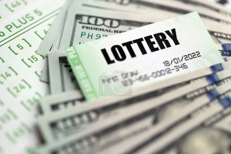 Grüne Lotterielose und US-Geldscheine auf Blanko mit Zahlen zum Lotteriespiel aus nächster Nähe