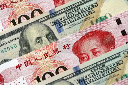 Many money bills of People Republic of China and United States. PRC Yuan and USD dollars banknotes close up