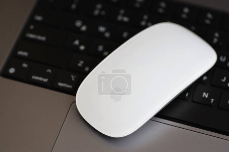 Photo for KYIV, UKRAINE - NOVEMBER 27, 2023 Apple Magic Mouse 3rd generation lies with grey MacBook 2021 close up - Royalty Free Image